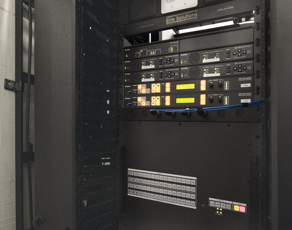 An equipment closet housing AV system central switching, scaling, streaming, and control equipment