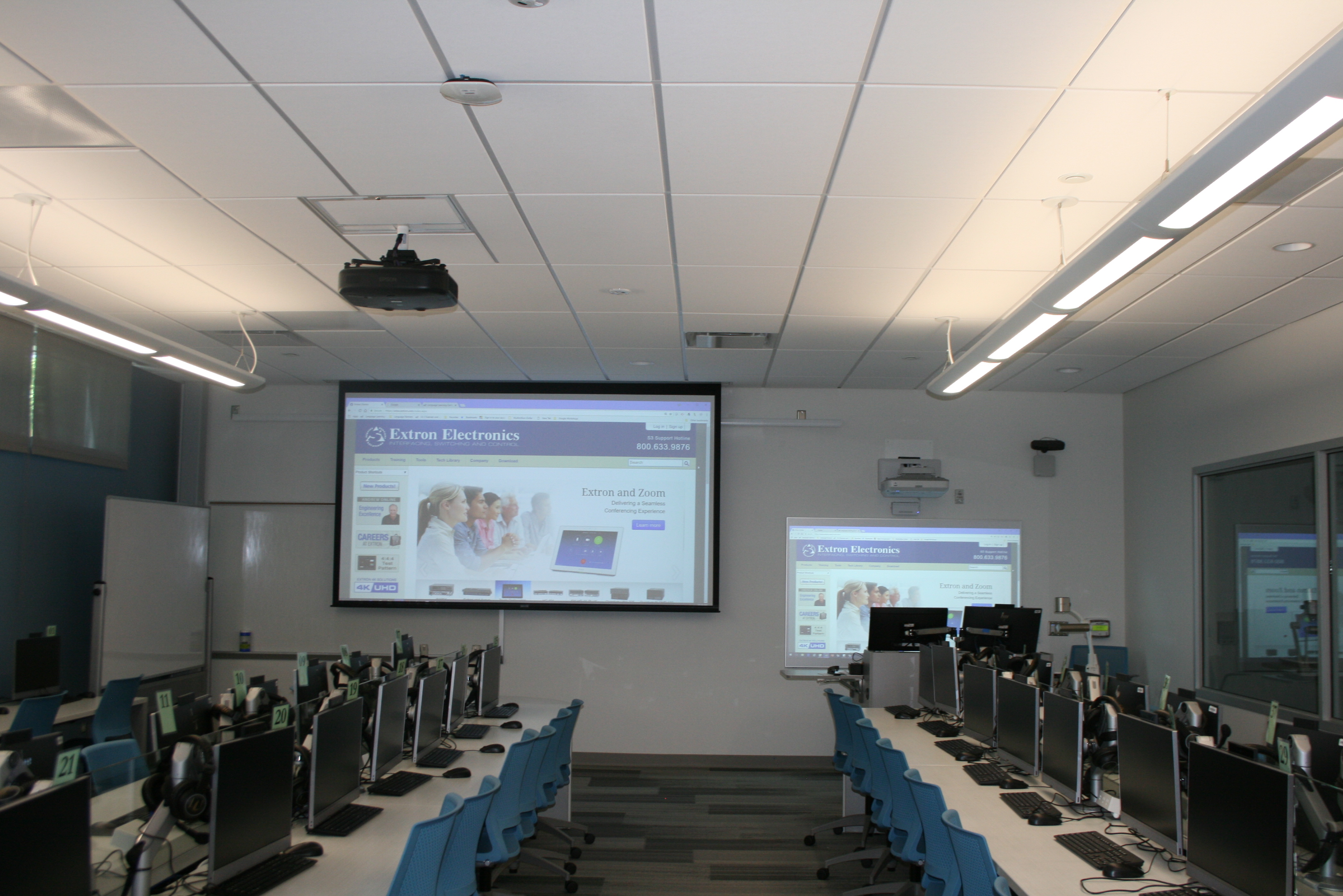 Classroom with a projection screen in front and to the side of the whiteboard