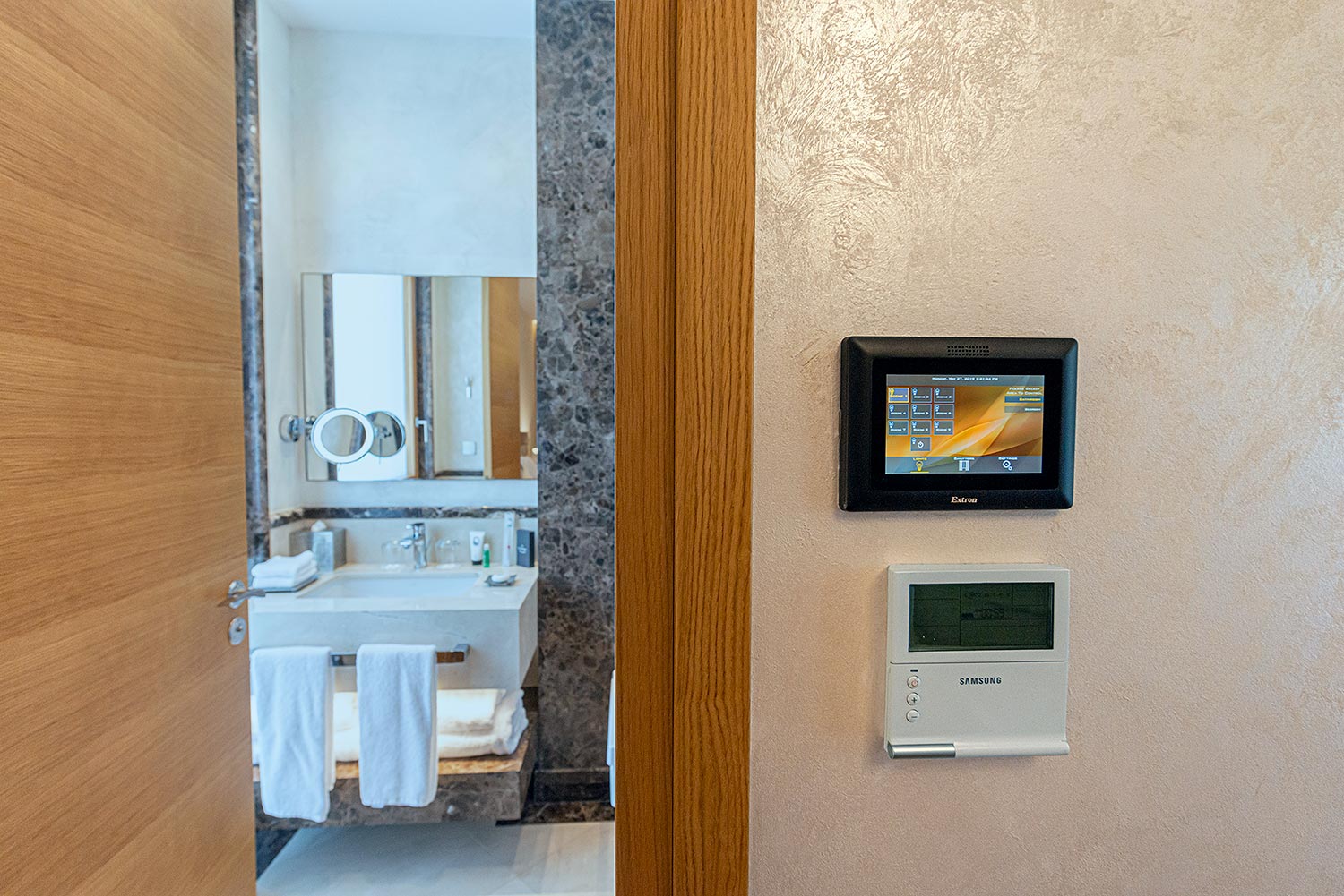 Wall-mounted touchpanel placed next to a bathroom entrance