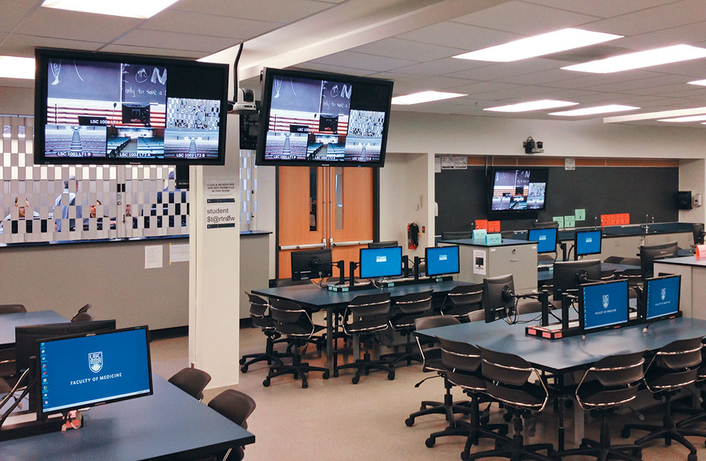 Each two-seat dry lab station includes two displays and a gooseneck microphone, allowing students to ask questions in real time.