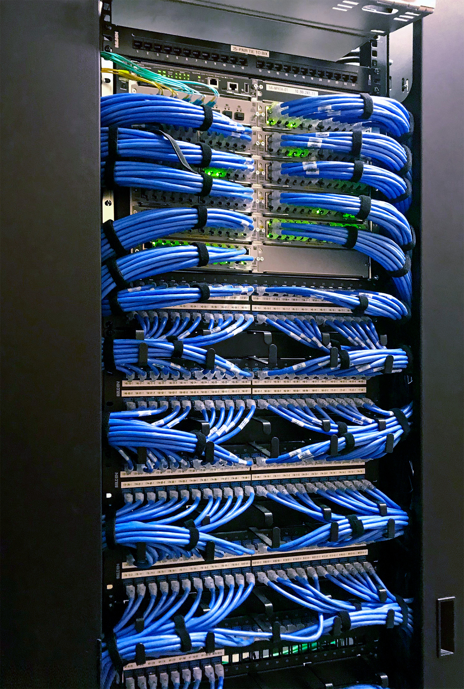Cabling of the equipment racks, such as this network rack that includes the Extron NAV Pro AVoIP system components, is dressed according to AV industry best practices.