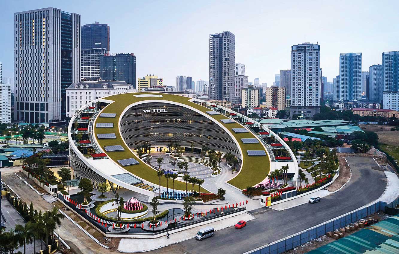 Viettel’s new Hanoi headquarters, designed by American architectural firm Gensler, curves and slopes from the foot to the top of the grass-covered roof in an oval shape inspired by the company logo.