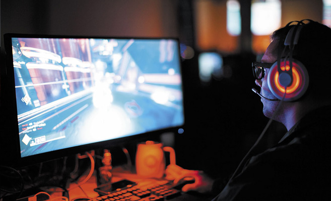 A man playing a video game on a desktop computer.