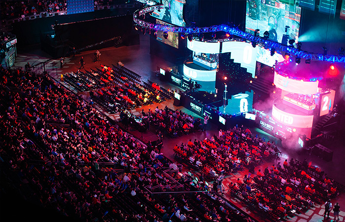 An aerial view of an Esports arena, and all of the screens surrounding the stage.