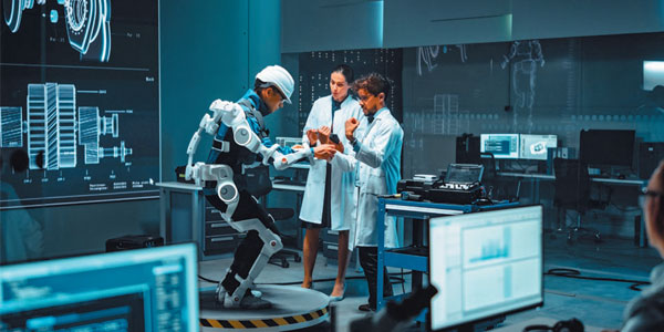 机器人实验室，一名技术人员在两名研究员的协助下穿着外骨骼机械装置进行测试。前景中的大型显示器显示着机械零件的 3D 视图