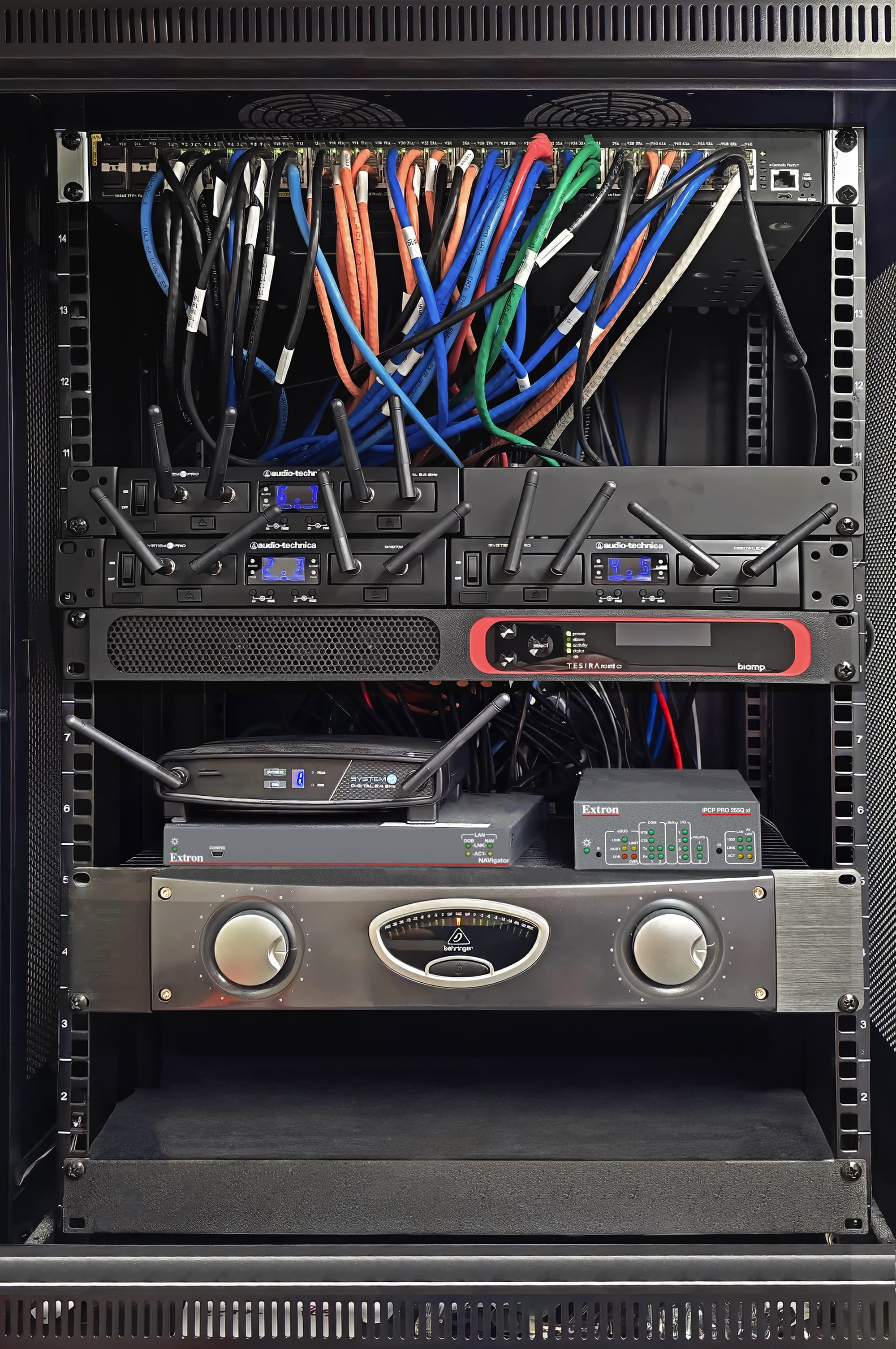 Les composants du système audiovisuel central (switch réseau, processeur de contrôle, NAVigator) sont contenus dans un rack fermé avec une porte transparente en plexiglas. Le rack est installé près du plafond dans le hall d'entrée de la salle de conseil.