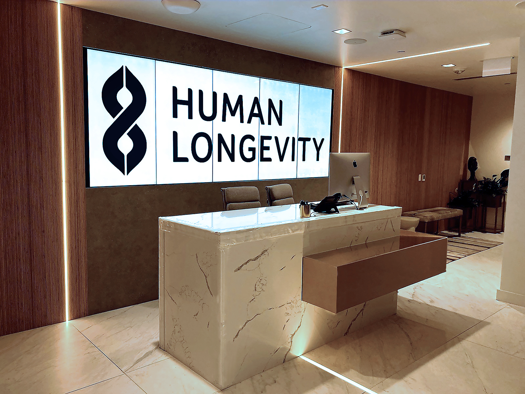 The main lobby features a portrait-oriented videowall behind reception, displaying dynamic branded content routed through Extron matrix switchers.