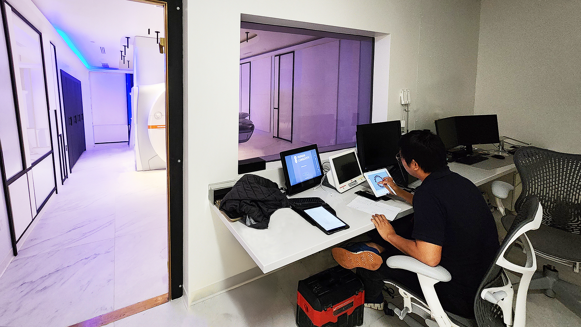 An AV Structural technician finalizing touchpanel configuration outside MRI room, where automation and privacy controls are managed through Extron interfaces.