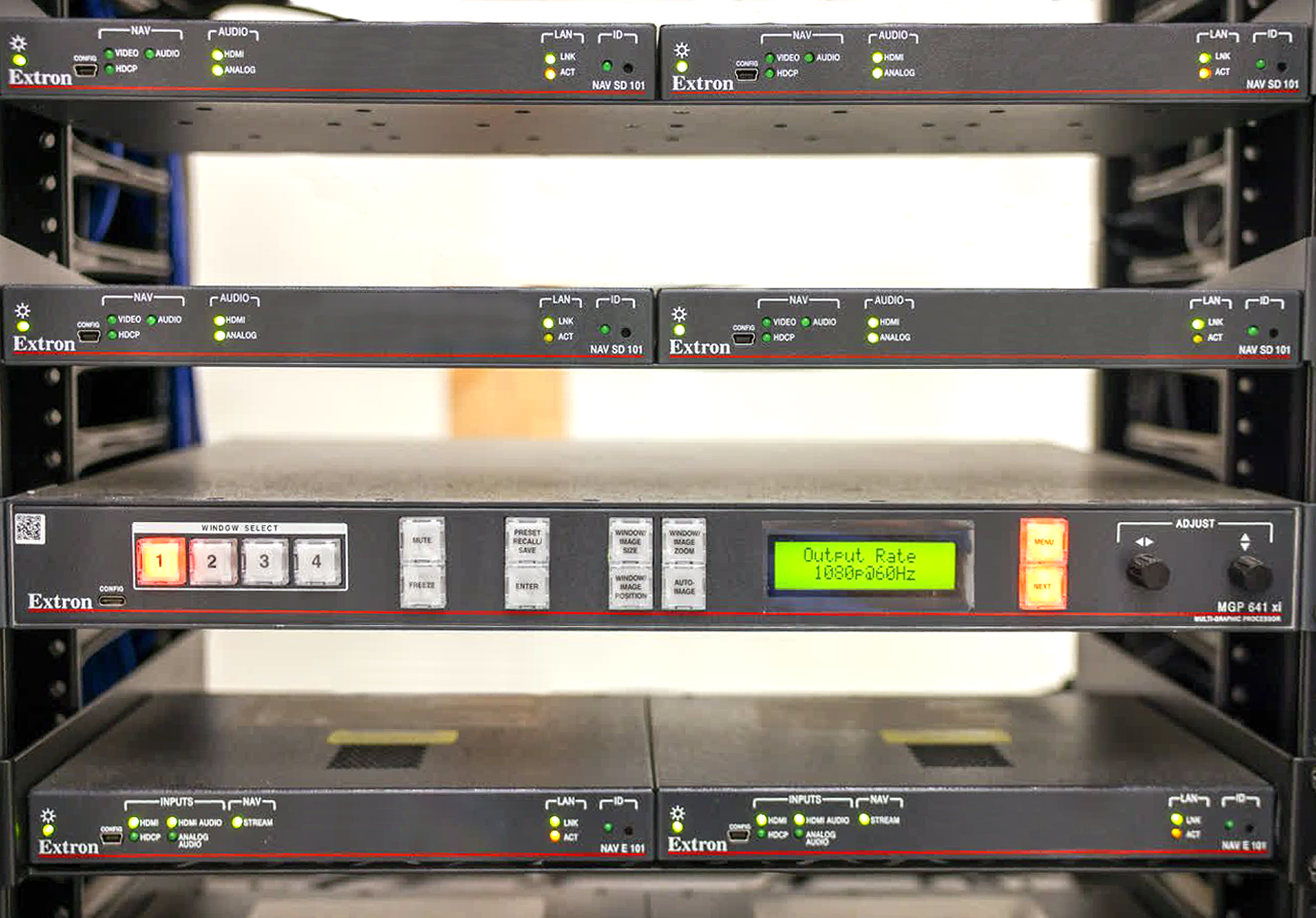 NAV encoders, scaling decoders, MGP 641s, network switches, and other AV equipment housed in racks located in the equipment room.