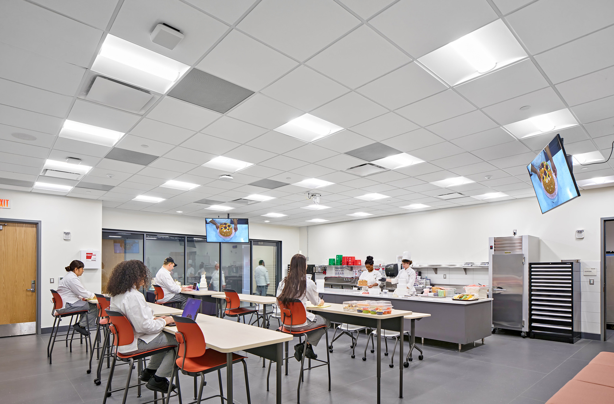 Cake decorating techniques taught in demonstration classroom are captured by ceiling-mounted PTZ camera for viewing on the flat panel displays.
