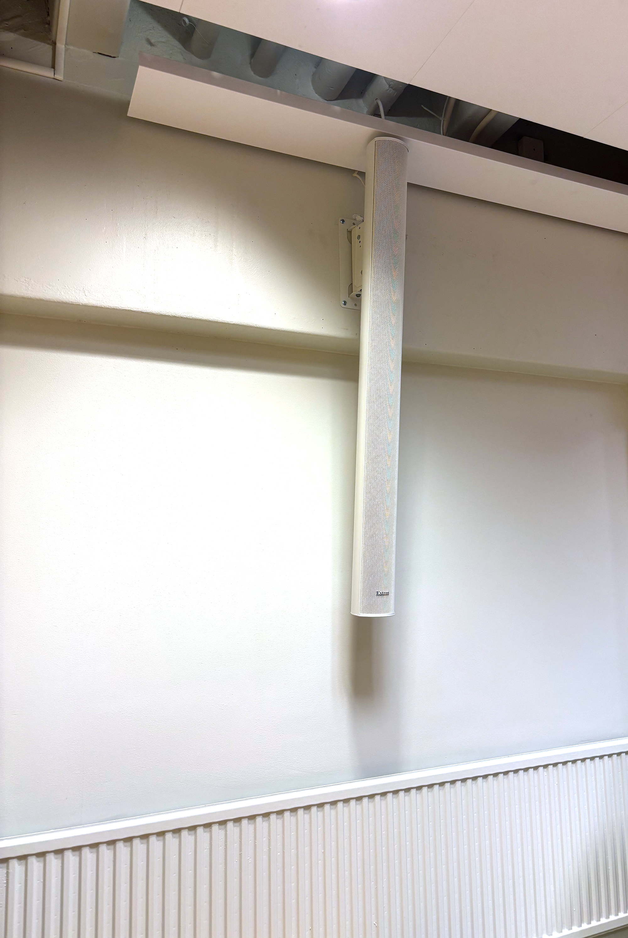 L'une des enceintes colonnes CA 163, peinte sur mesure pour se fondre dans le mur, offre un renforcement sonore intelligible sans altérer l'esthétique architecturale.