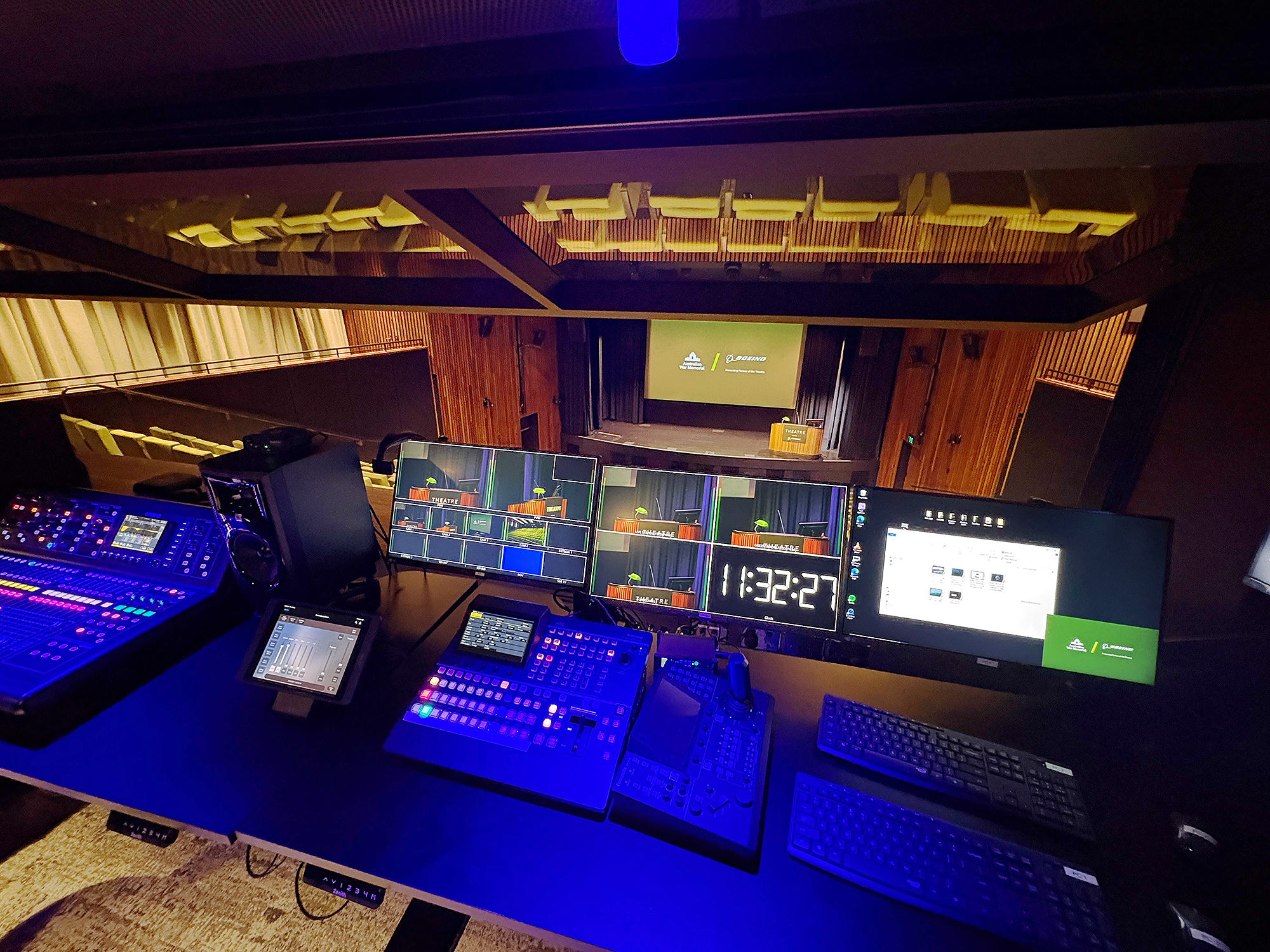 The theatre control room provides full oversight of video and audio workflows, with monitors, mixer, and TouchLink Pro touchpanel supporting live event operation.