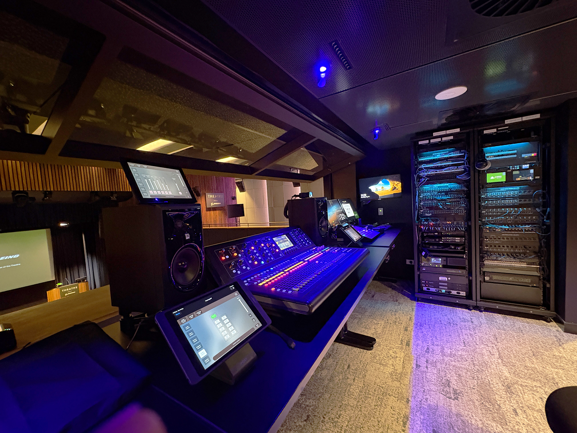 An Extron TouchLink Pro touchpanel sits near the mixing board to provide easy access to volume and input controls.