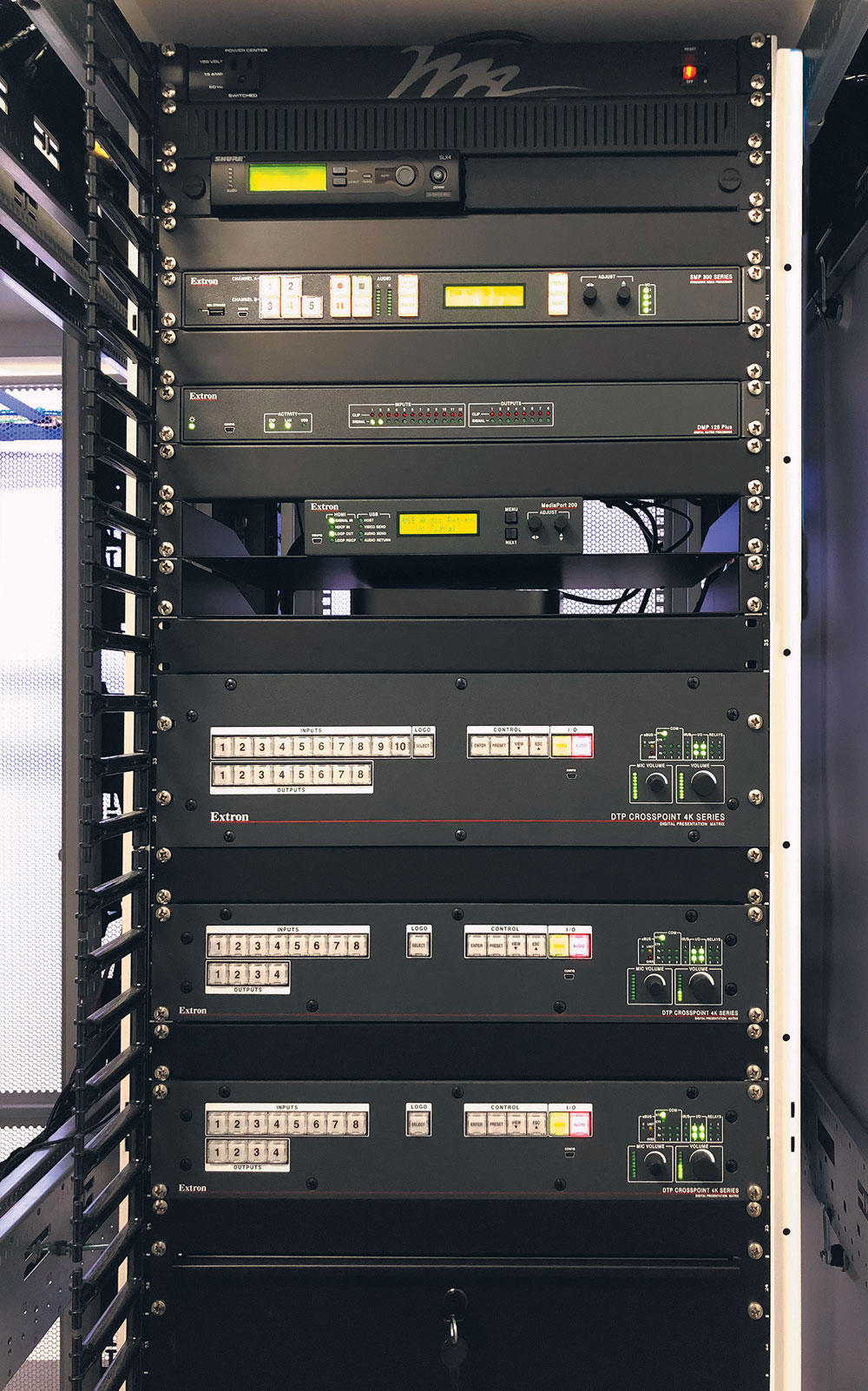 SMP 351-Prozessor für Medien-Streaming (oben im Rack) zur Übertragung von Schulungseinheiten an entfernte Standorte oder zur Aufzeichnung für Video-on-Demand. DTP CrossPoint 4K-Präsentationskreuzschienen (in der Rackmitte) liefern 4K-Umschaltung und ‑Skalierung sowie integrierte Steuerungsfunktionen und Audioverstärkung.