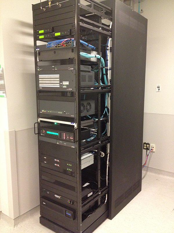 The FOX Matrix 3200, sound system, and other AV equipment are rack-mounted in a nearby space.