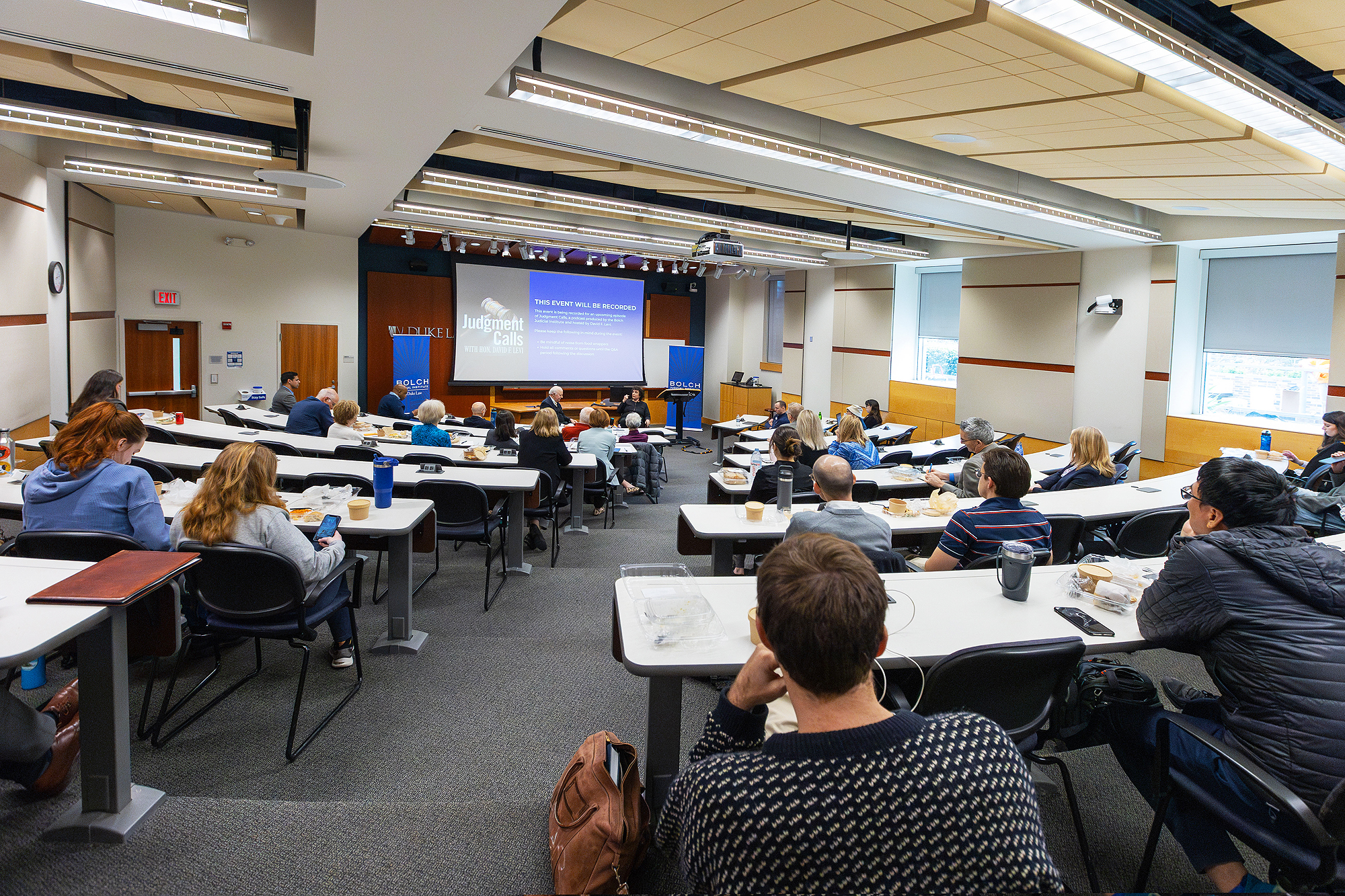 Room 3037 lecture hall with a projection screen, plus side flat panel display. Accommodates 89 students and four instructors.