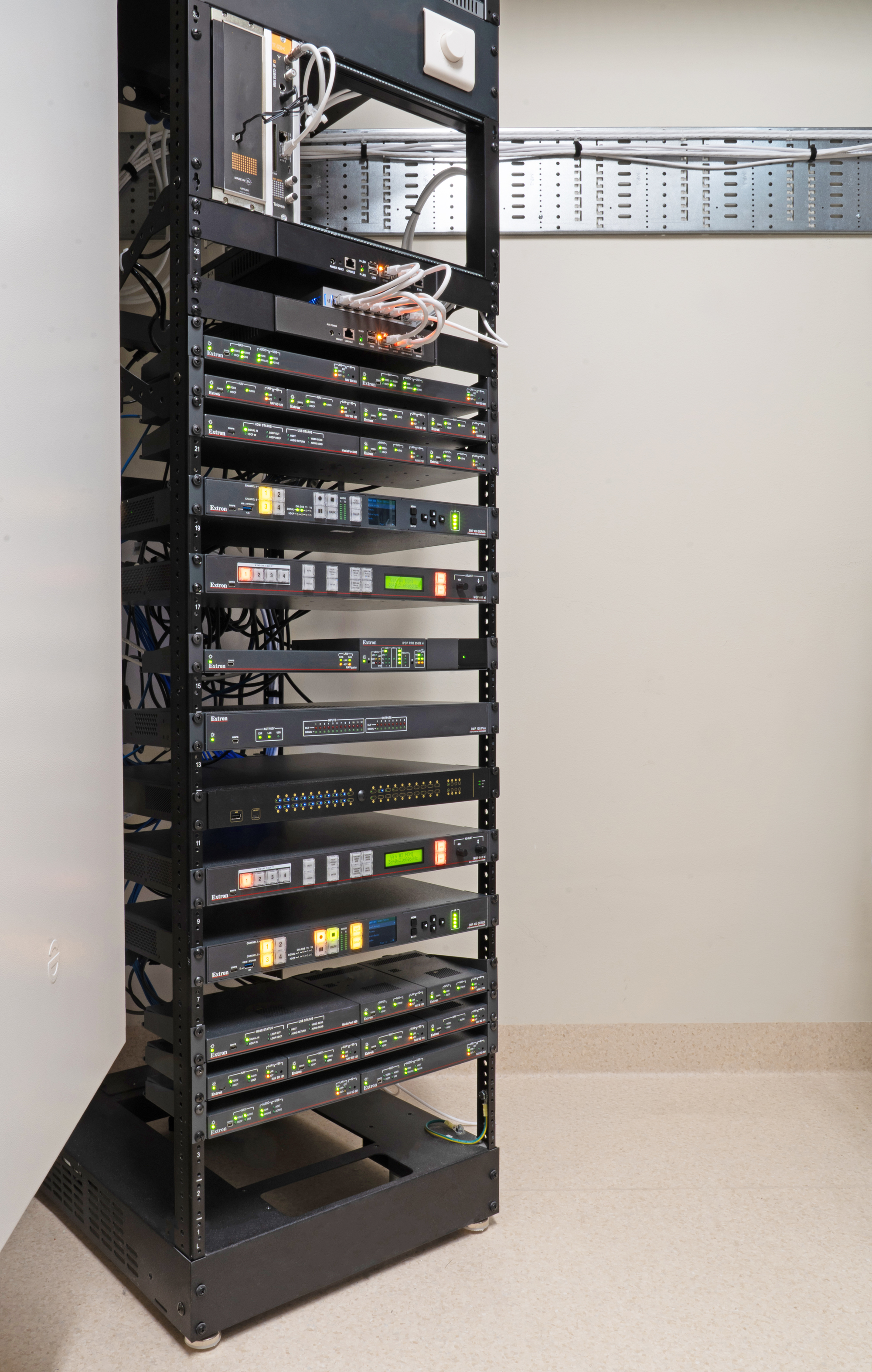A central AV rack at The Faculty is home to the NAVigator NAV System Manager, along with switching, audio processing, and control processing products.