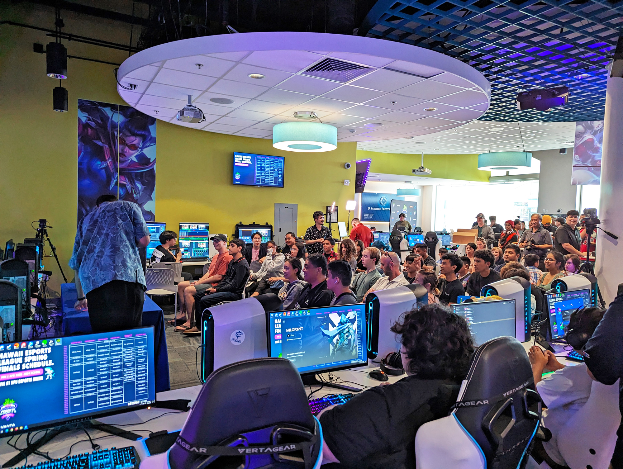 Seating on the arena floor allows observers and competitors knocked out of a match to follow the action on one of the projection screens or a display.