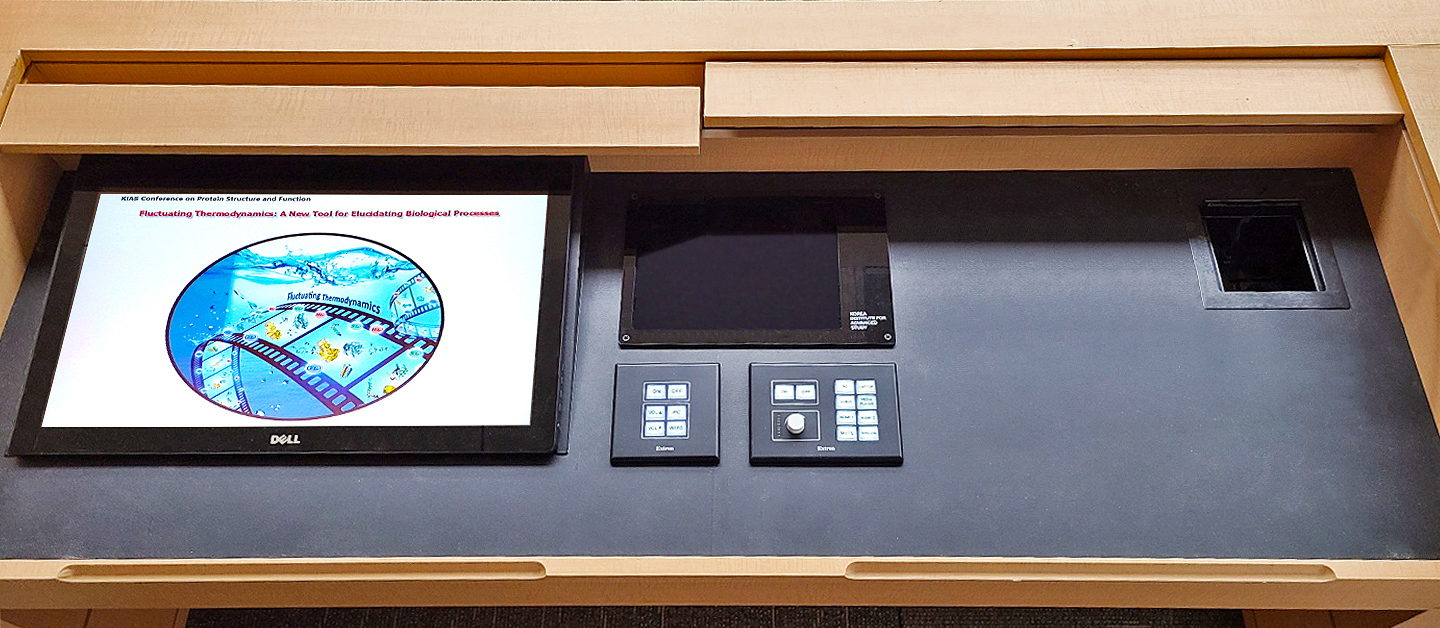 Le pupitre. Claviers de commande et interface tactile interactive sur iPad qui constituent l'interface audiovisuelle du système de vidéoconférence. L'écran du PC du pupitre est sur la gauche. L'ordinateur portable d'un intervenant extérieur peut se connecter via un câble Ethernet placé dans le coin supérieur droit du compartiment. Reproduction autorisée par Neuroo Digitech.