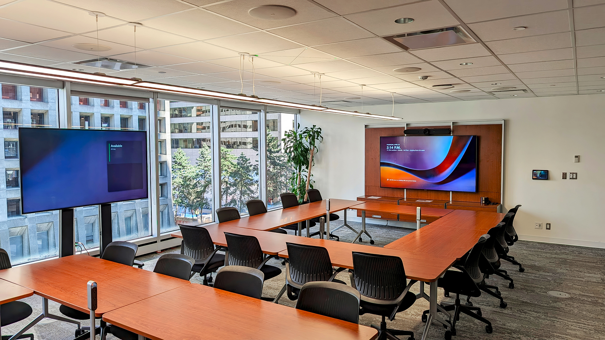 The newly designed multipurpose room features two large conference tables and advanced AV displays for versatile meeting setups.