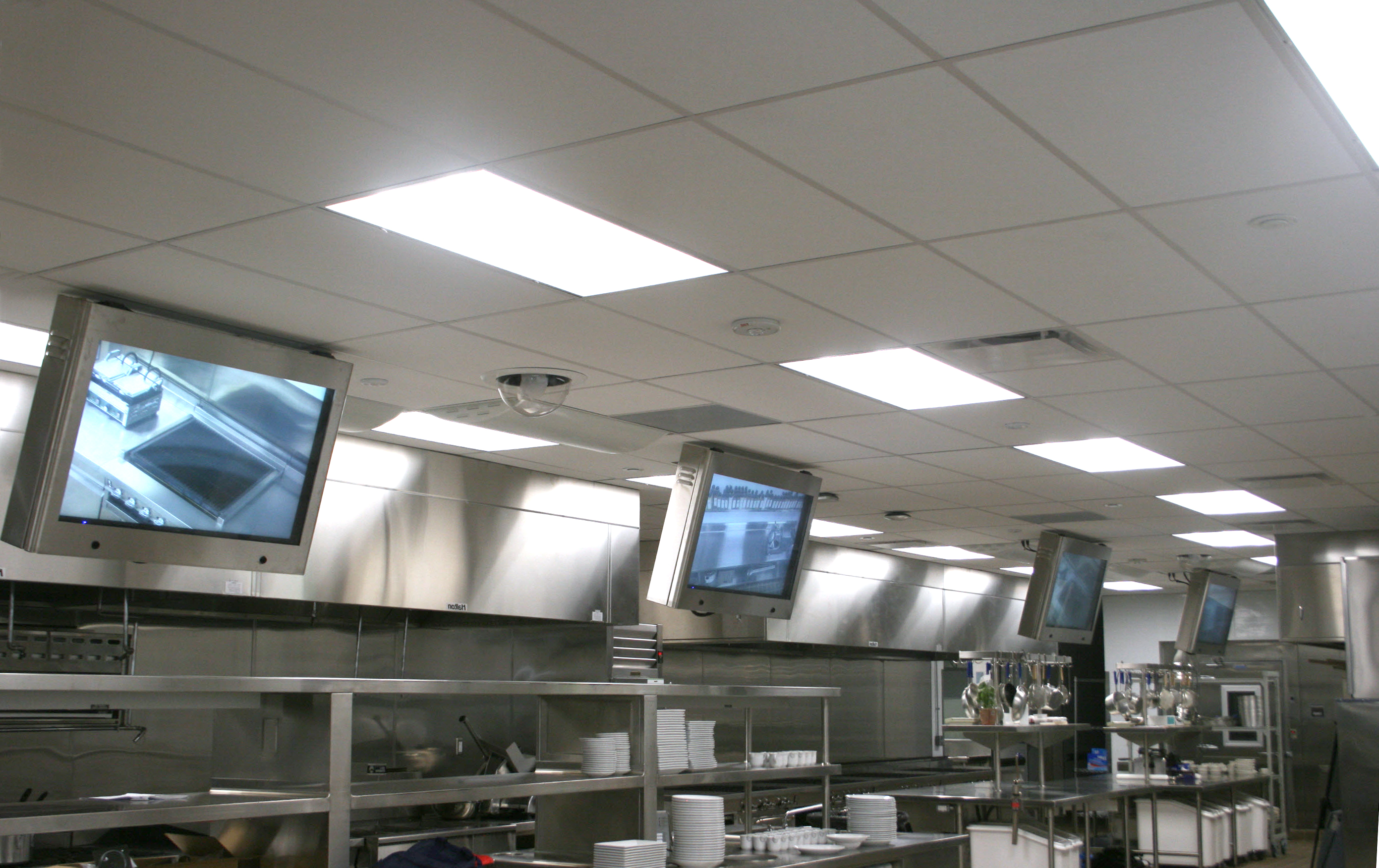 Flat panel displays that are angle-mounted above kitchen workstations