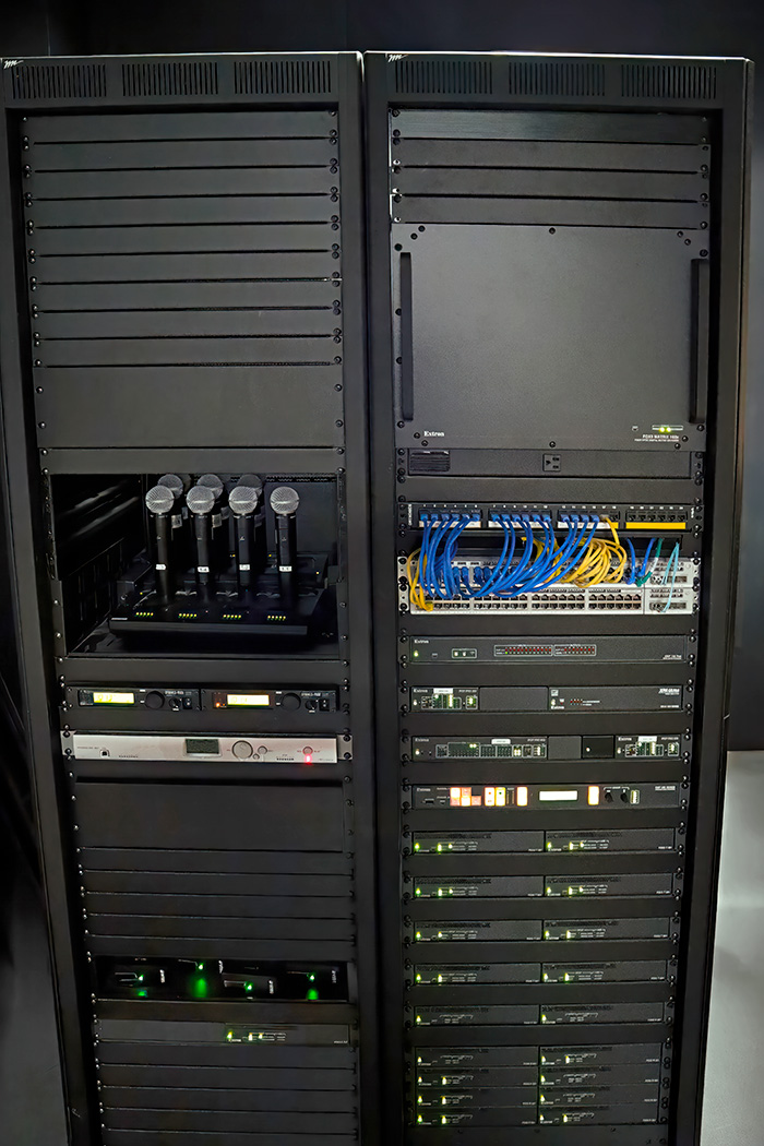Racks in the equipment room adjacent to the Command Center contain a variety of sources and the Extron video, audio, streaming, and control products.