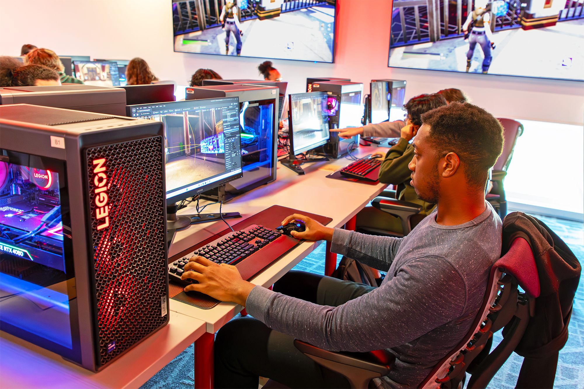 Students relax after class while playing on cutting- edge Lenovo Legion T7 gaming PCs.