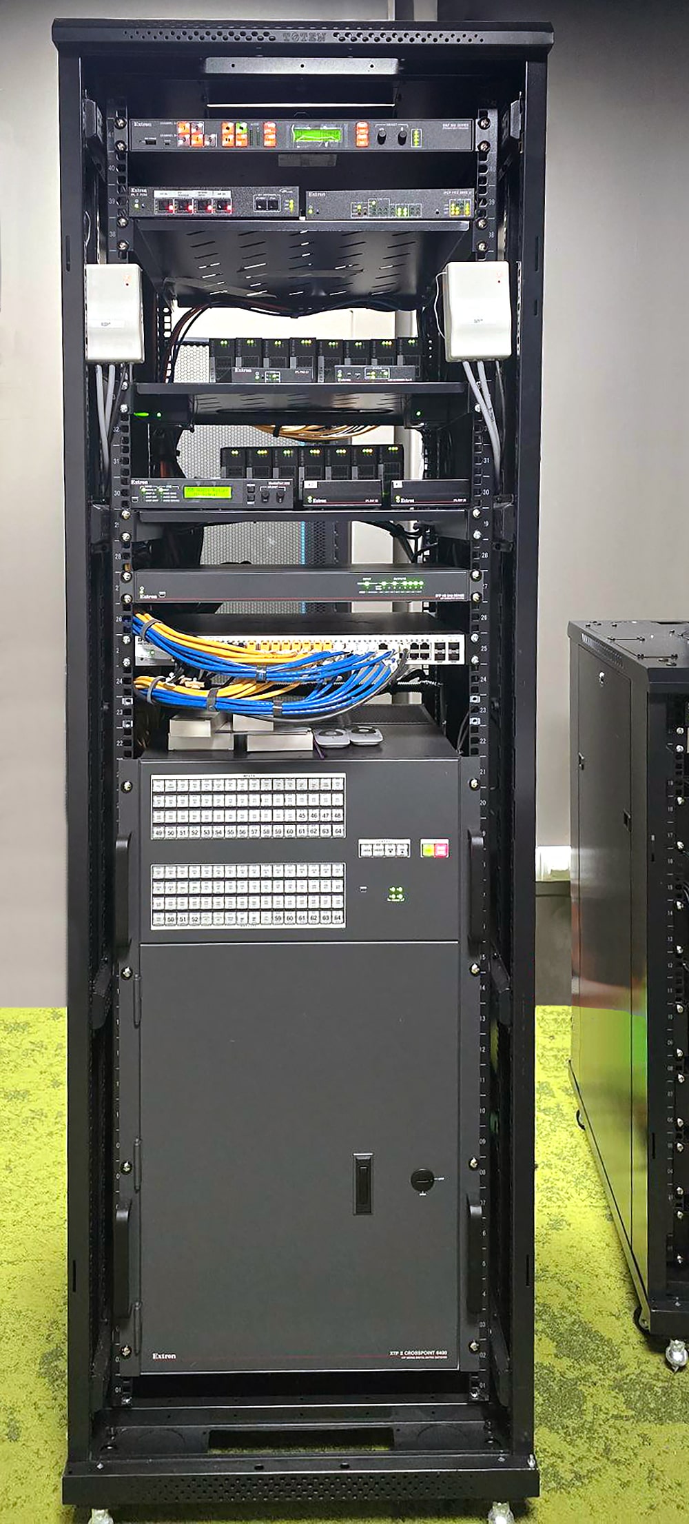 La baie audiovisuelle pour la salle de collaboration 1 comprend les équipements de commutation, de traitement, et de contrôle Extron qui assurent le fonctionnement du système audiovisuel de la salle.