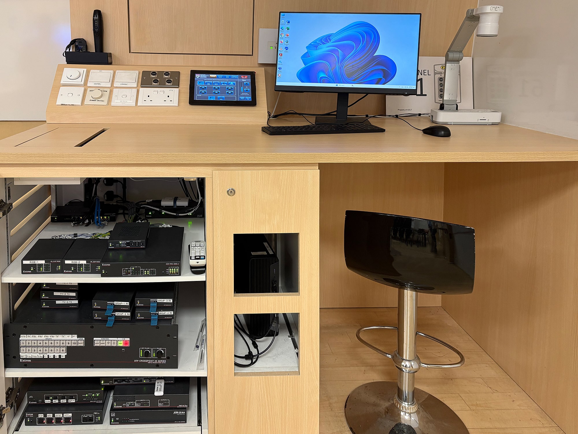 Le bureau de l'enseignant dans une salle de tutorat occupe efficacement l'espace et offre un accès facile aux commandes du système, à la connectivité, et aux équipements audiovisuels.