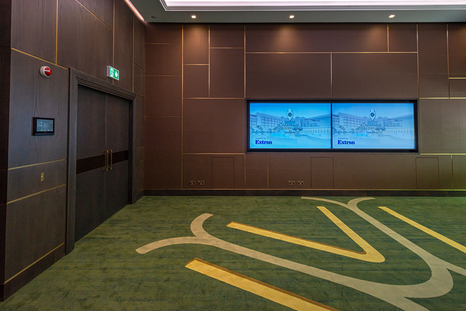 Vignette de l'espace d'accueil de l'hôtel avec deux écrans muraux
