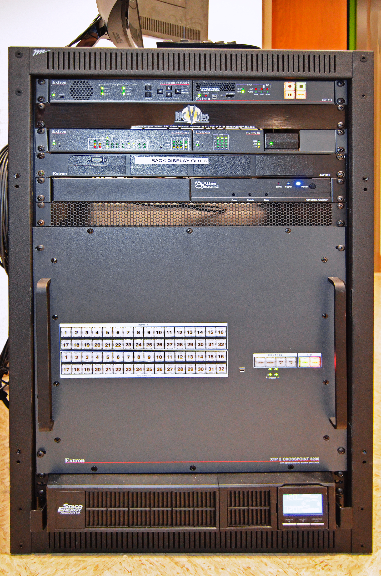 The XTP II CrossPoint 3200 matrix switcher and other system components are rack-mounted in the adjacent equipment room. This space is also used to store spare gaming gear and provides a small work space with a connected monitor.
