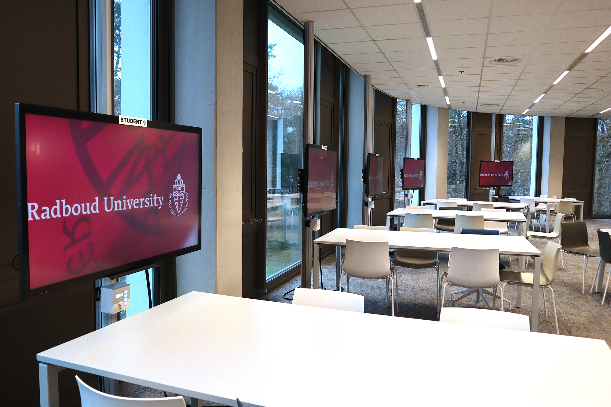 Each student cluster features a flat panel display and an Extron NBP 100 Network Button Panel, giving students local control over source selection, volume, and power.
