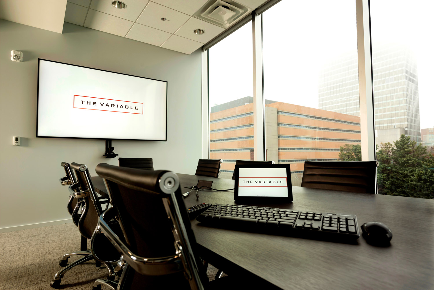 A small conference room with a touchpanel on the desk.