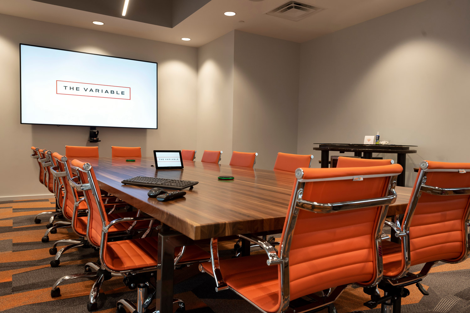 A large conference room with a touchpanel placed on the desk.