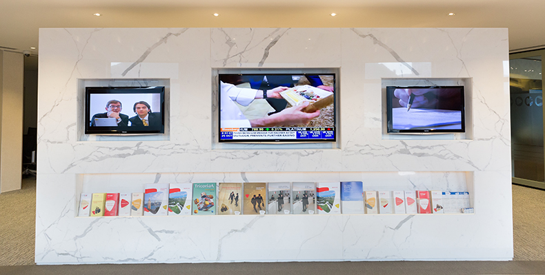 Flat panels within the reception area on Level 54 display company and product information for visitors.