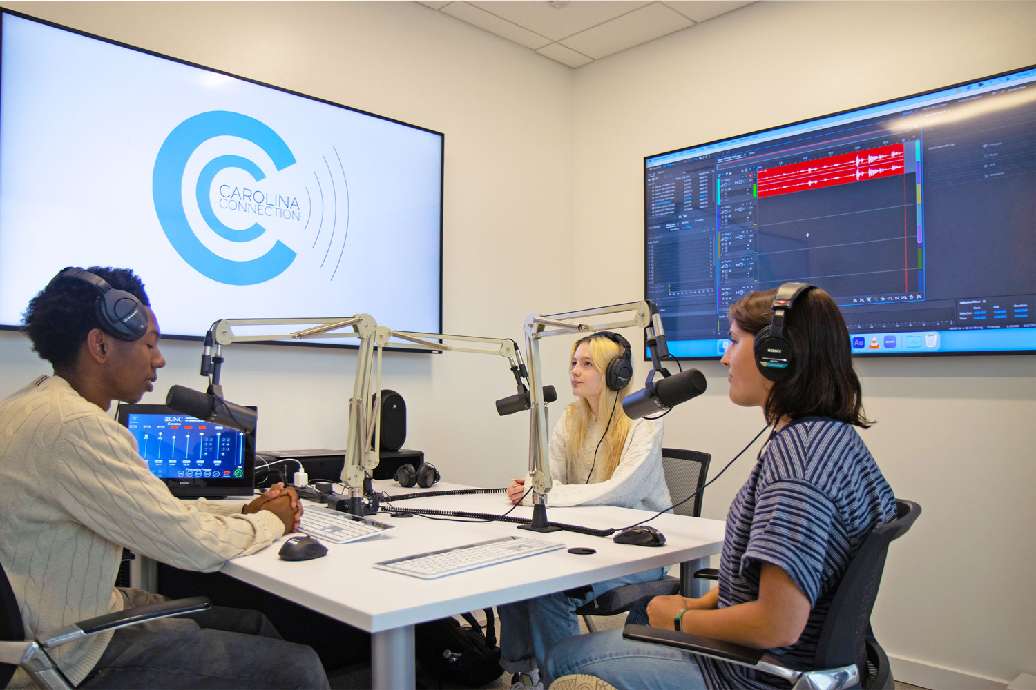 Podcast studio accommodates group discussions with mics and headphones for up to three people.
