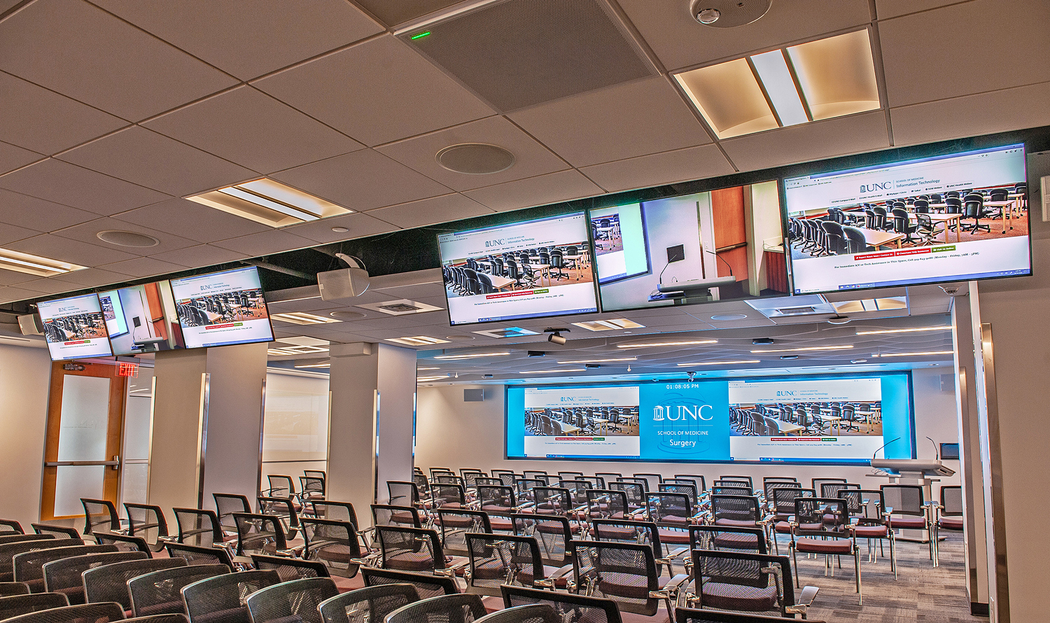 An empty surgical education room at a university medical center with a row of displays and a large videowall display.