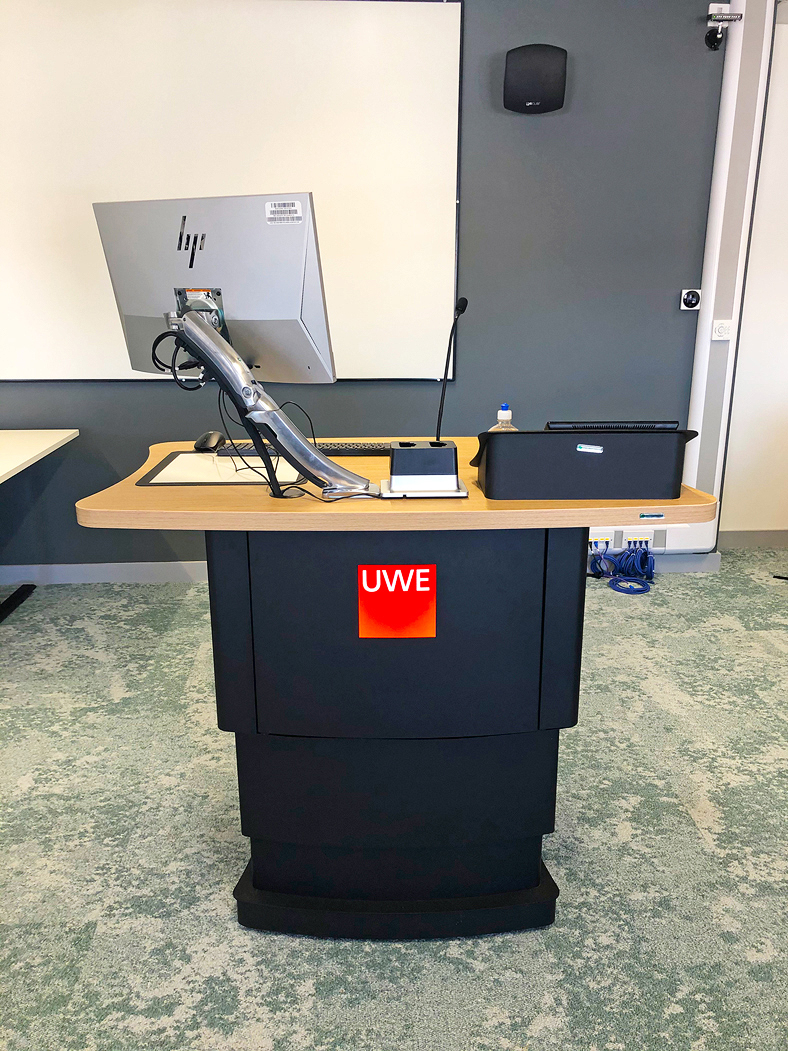 Thumbnail - Using a raceway, the lectern is stationed in the middle of the flexible classroom. This room arrangement allows the instructor to monitor activities at each student pod while easily controlling the AV system when necessary.