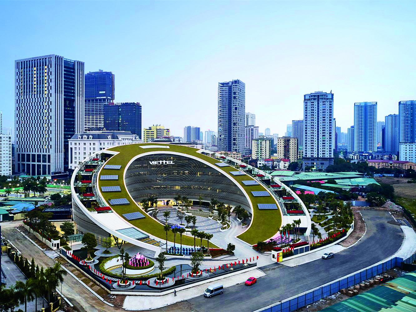 Viettel’s new Hanoi headquarters, designed by American architectural firm Gensler, curves and slopes from the foot to the top of the grass-covered roof in an oval shape inspired by the company logo.