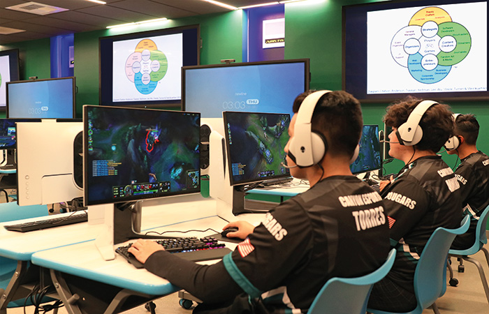 Ein Gamer spielt ein Videospiel auf einem Desktop-Computer auf einer Bühne.