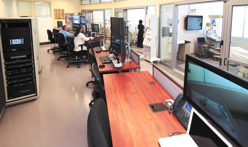 Un centro de supervisión junto a tres laboratorios de simulación en una escuela de enfermería.